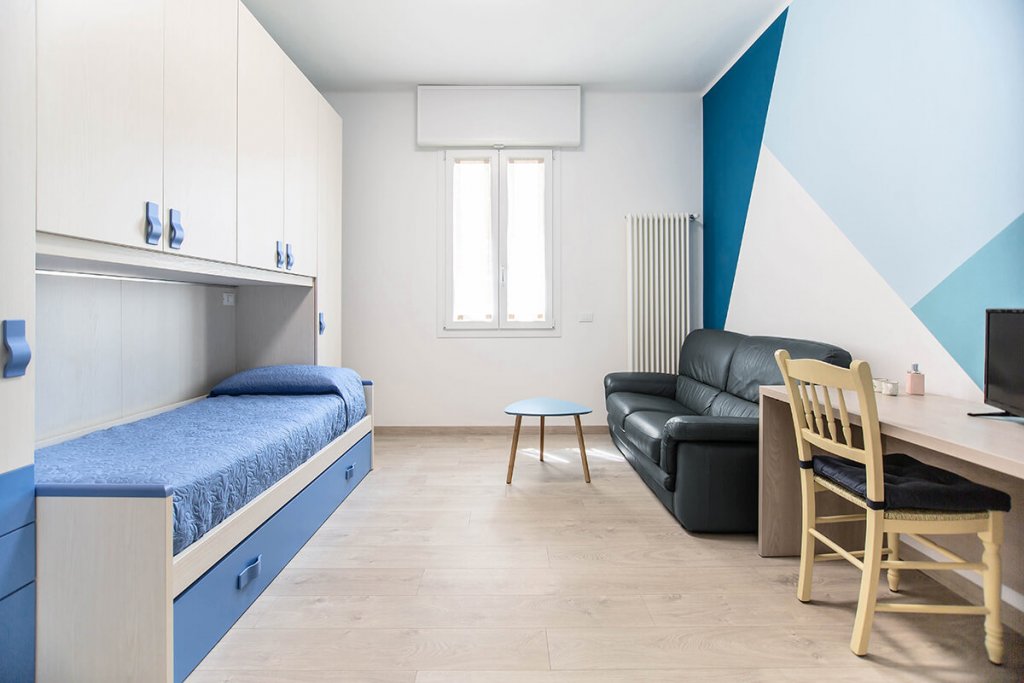Camera da letto singolo con divano e scrivania