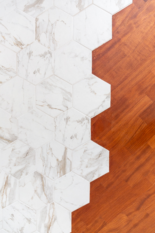 cementine esagonali effetto marmo venato su parquet.