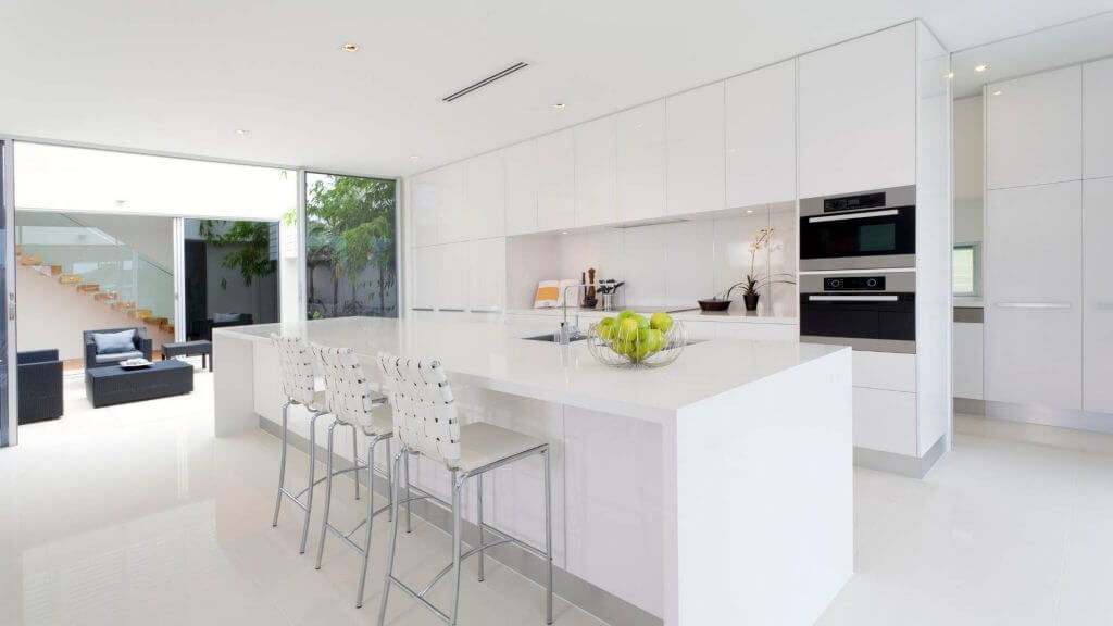 Cucine ad isola: pro e contro | Facile Ristrutturare Cucina bianca con isola con sgabelli bianchi e lavello.