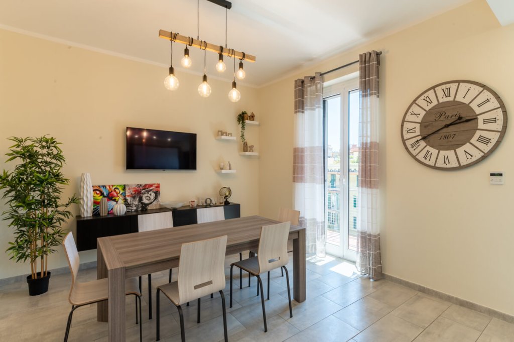Ristrutturazione Cucina moderna con tavolo in legno scuro e sedie in legno chiaro.