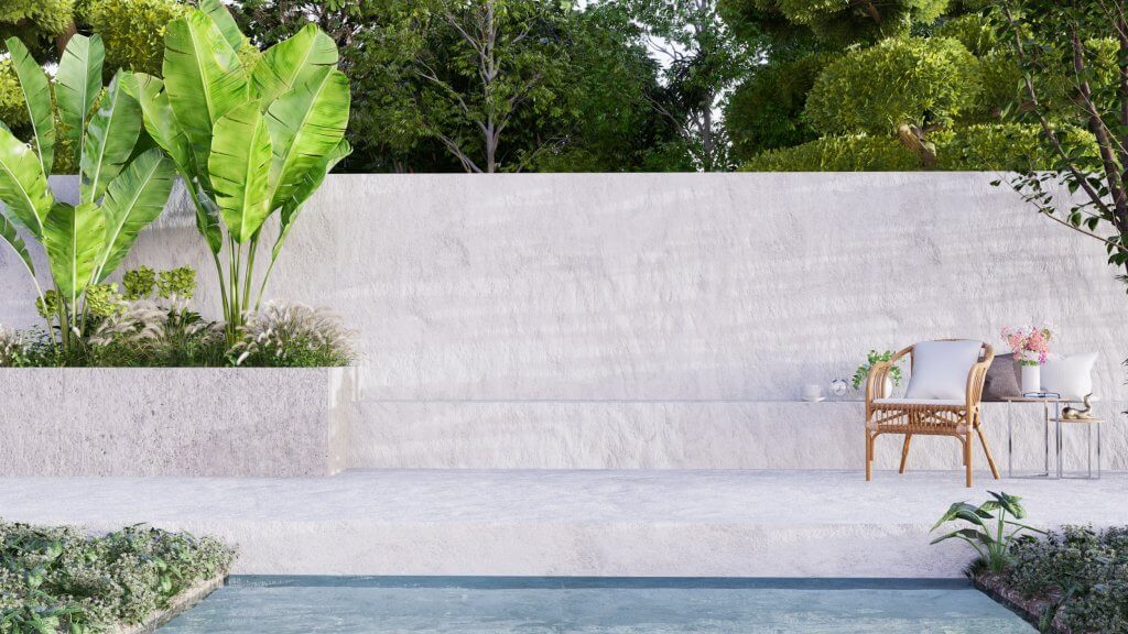 Pavimenti e rivestimenti terrazzo: idee e consigli | Facile Ristrutturare Giardino con sedia in legno, vasi sul tavolo e parete in roccia bianca