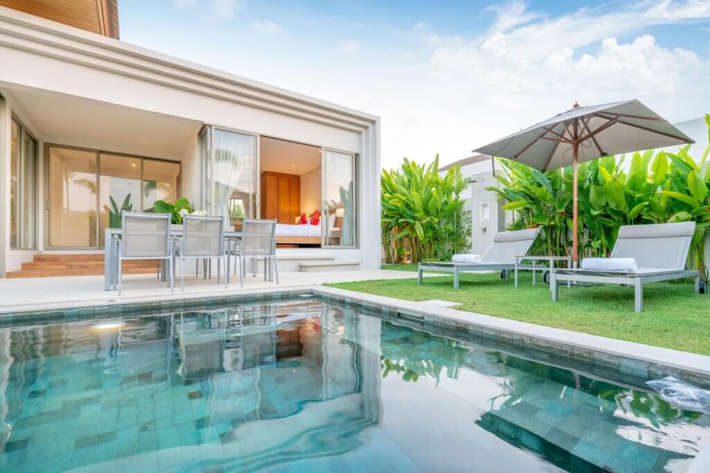 Quale piscina scegliere? Un tuffo tra i nostri consigli! | Facile Ristrutturare Casa con giardino e piscina, sdraio e lettini con ombrellone e sedie in plastica