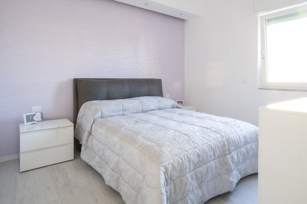 camera da letto con parete dai toni pastelli