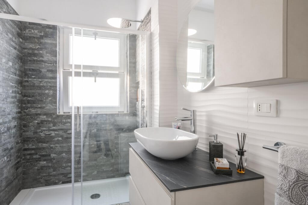 bagno con piastrelle effetto pietra per il box doccia